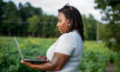 Woman using a laptop in a field