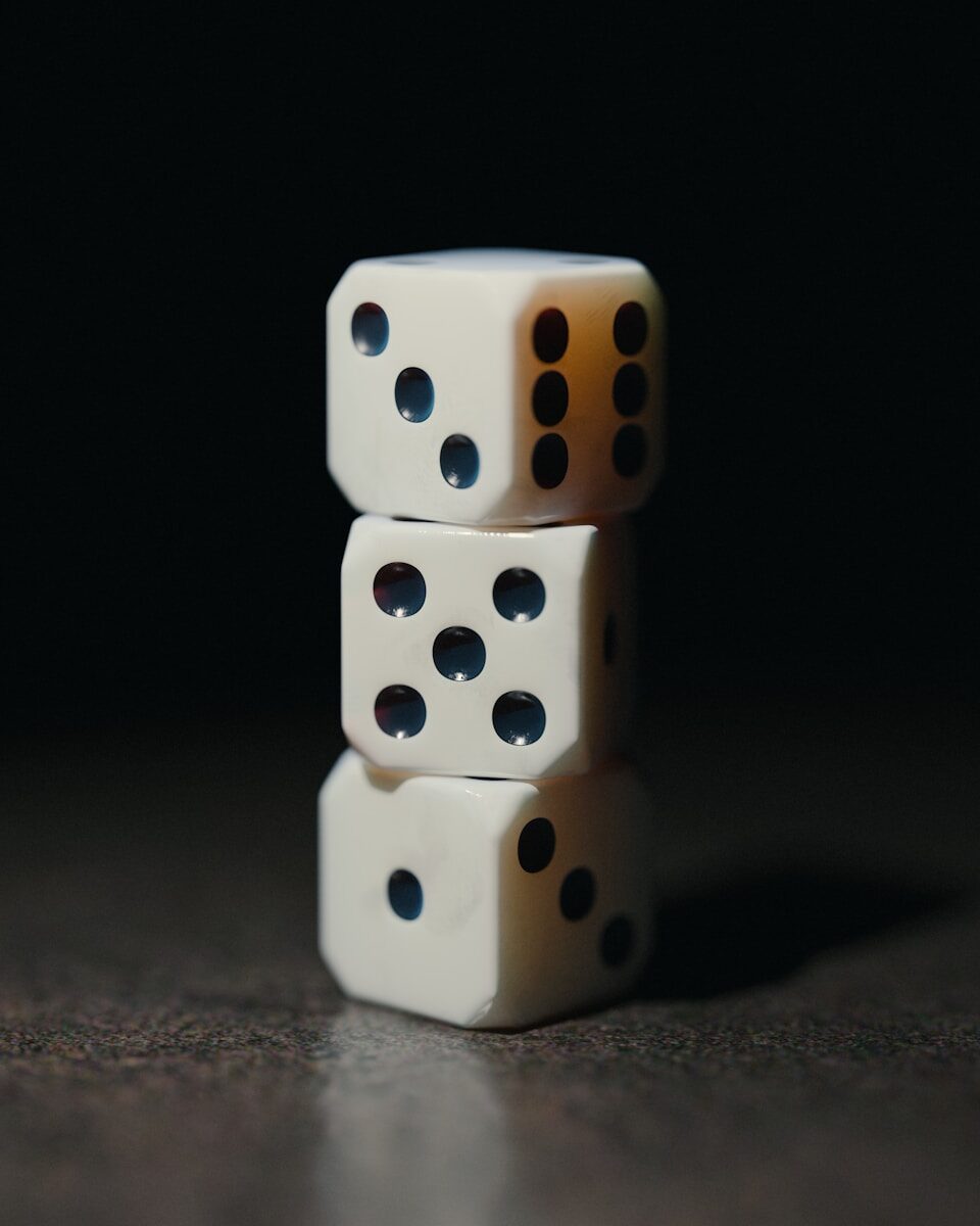 Three white dice stacked against a dark background.